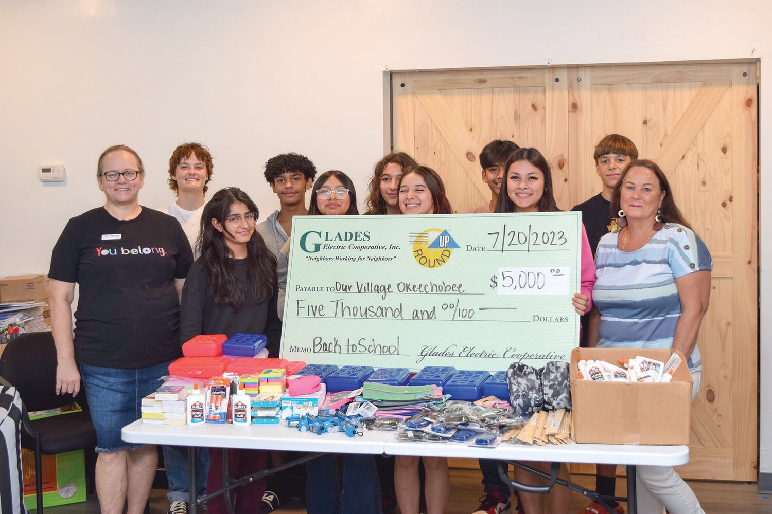 Left to right: Our Village Okeechobee Executive Director Leah Suarez (left) with Our Village students and Glades Electric Charitable Trust board member Paula Byars (right) as students prepared school supplies for the Our Village Back to School Expo.